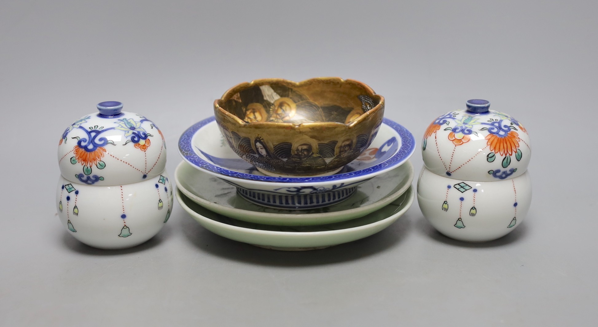 A pair of Japanese Nabesima style jars and covers and a similar footed dish, together with a Japanese Satsuma bowl, 11cm diameter and two plates (5)